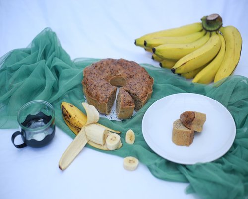 Assortment of bananas spinach and potatoes on wooden table